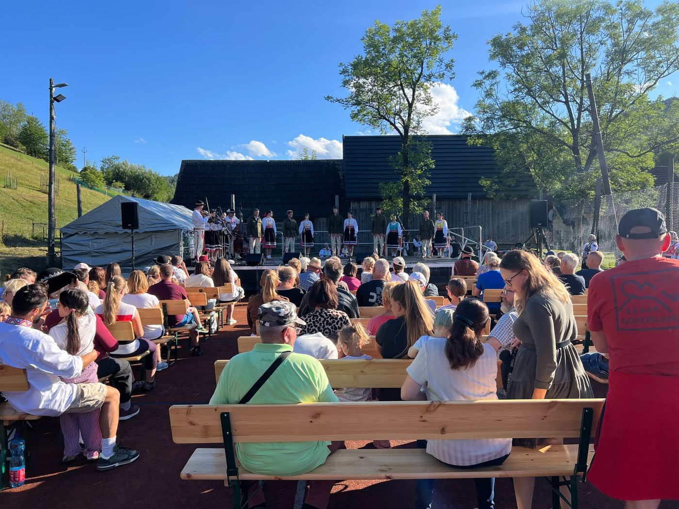 Audience on benches in front of the open-air stage at the Zogrod festival in Malá Franková